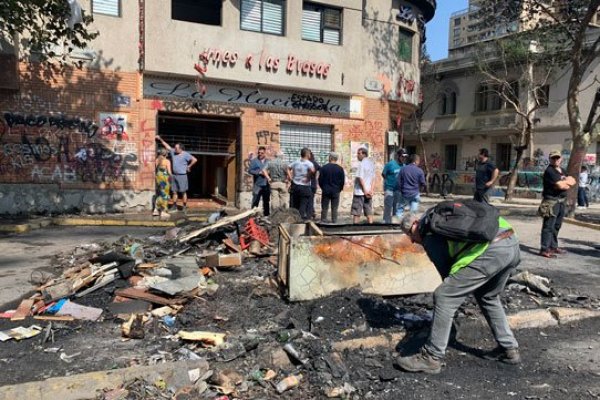 Trabajadores y clientes del restorante ubicado a pasos del Metro Baquedano limpian escombros tras incendio.
