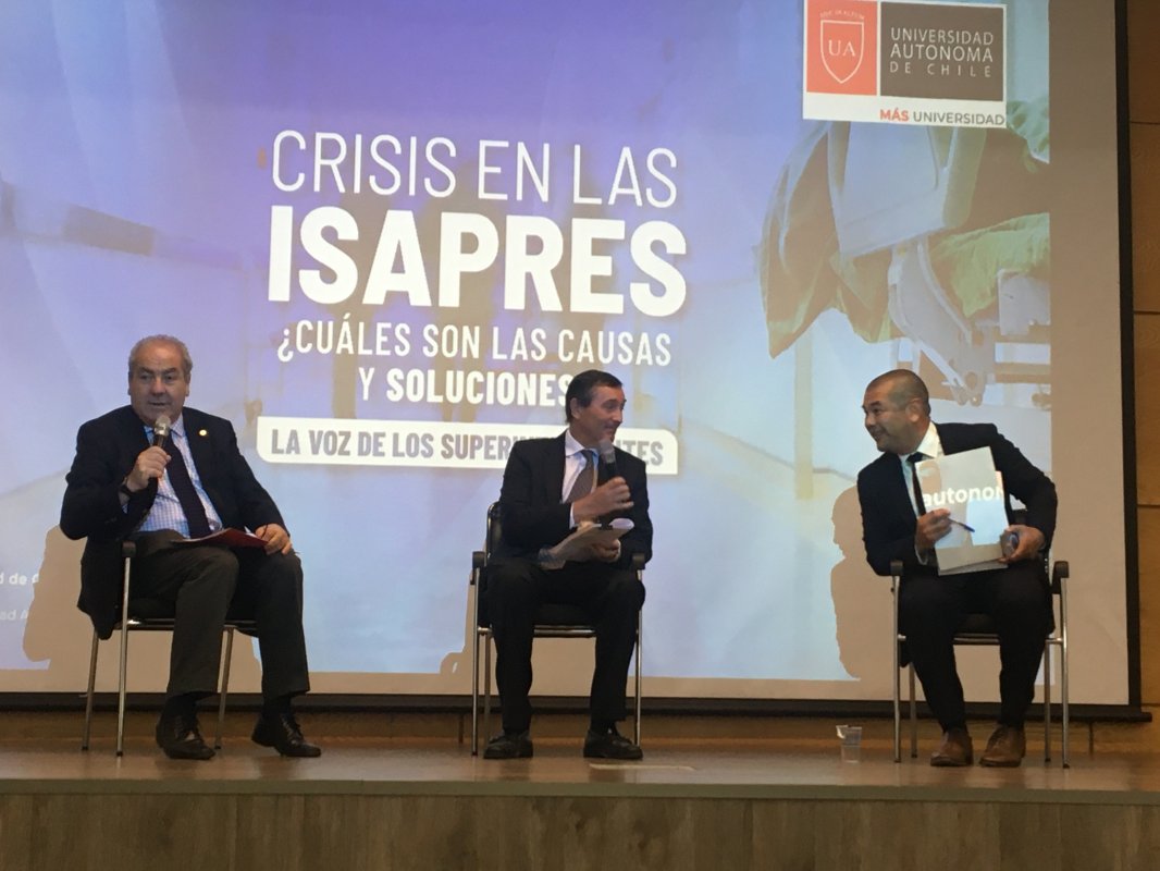 <p>El presidente de la Asociación de Isapres, Gonzalo Simón (al medio), y el superintendente de Salud, Víctor Torres (a la derecha), se vieron las caras en un seminario de la Universidad Autónoma.</p>